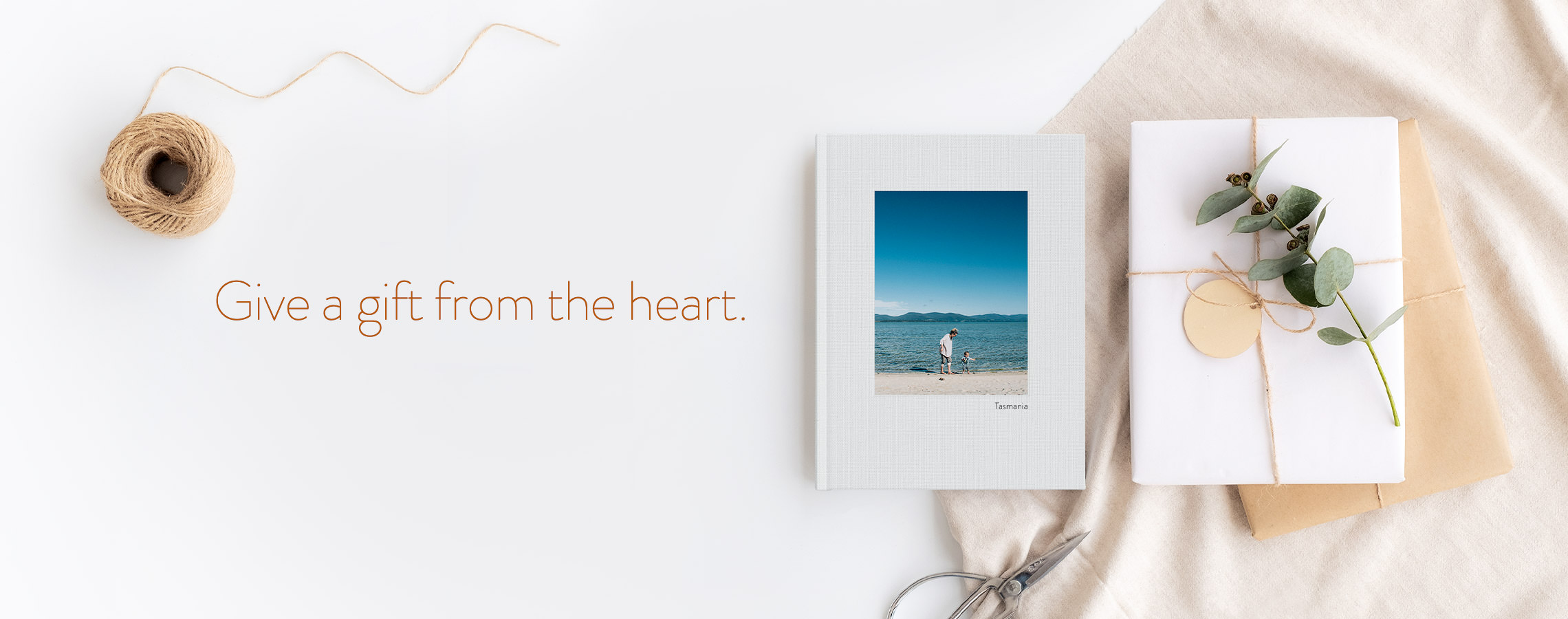 Give a gift from the heart. Photo Book next to a gift.