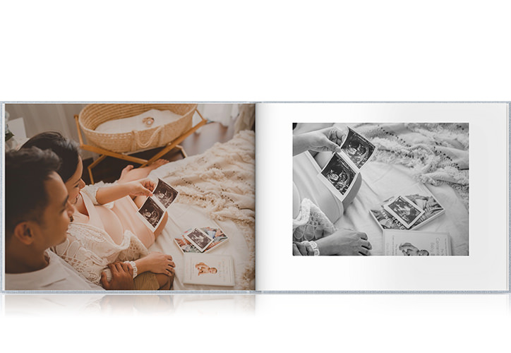 Open photo book with couple looking at ultrasound pictures of their baby