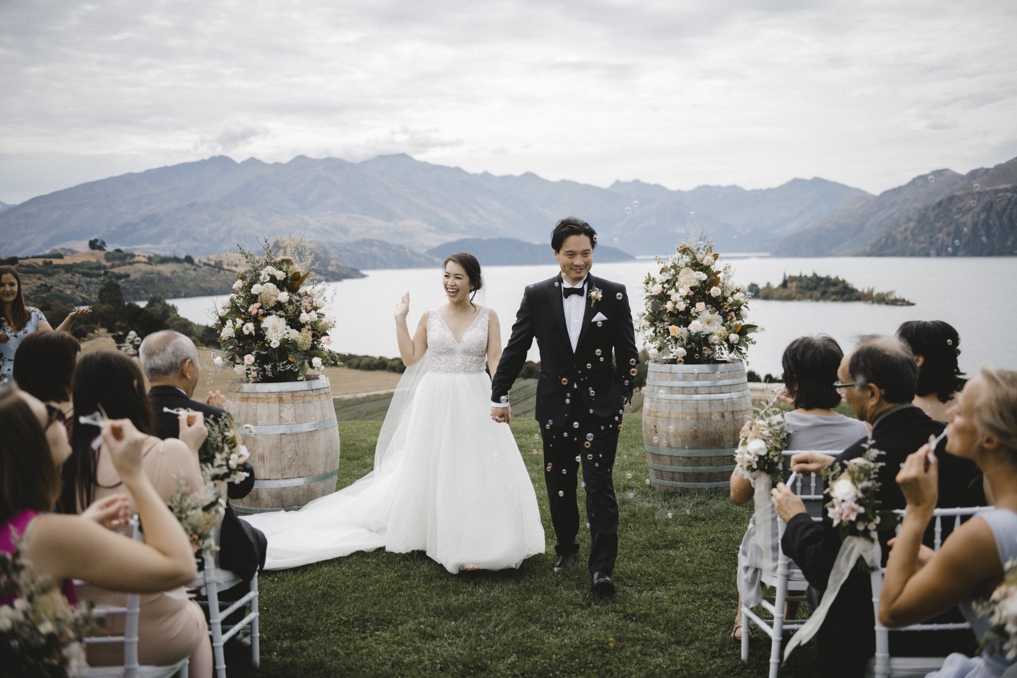 Newlyweds walk back down aisle as guests blow bubbles