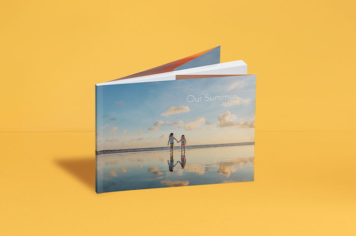 Softcover-Fotobuch mit Titelbild von zwei Mädchen am Strand.