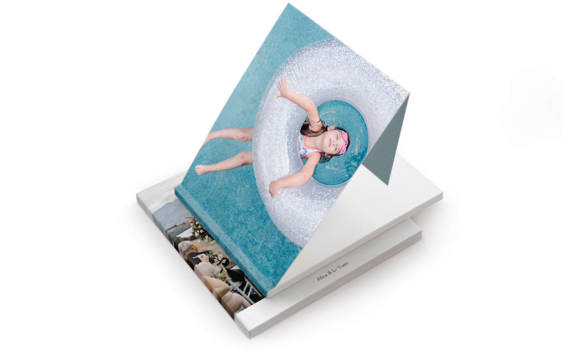 Zwei Softcover-Fotobücher, eines leicht geöffnet, um den inneren französischen Faltbezug zu zeigen.