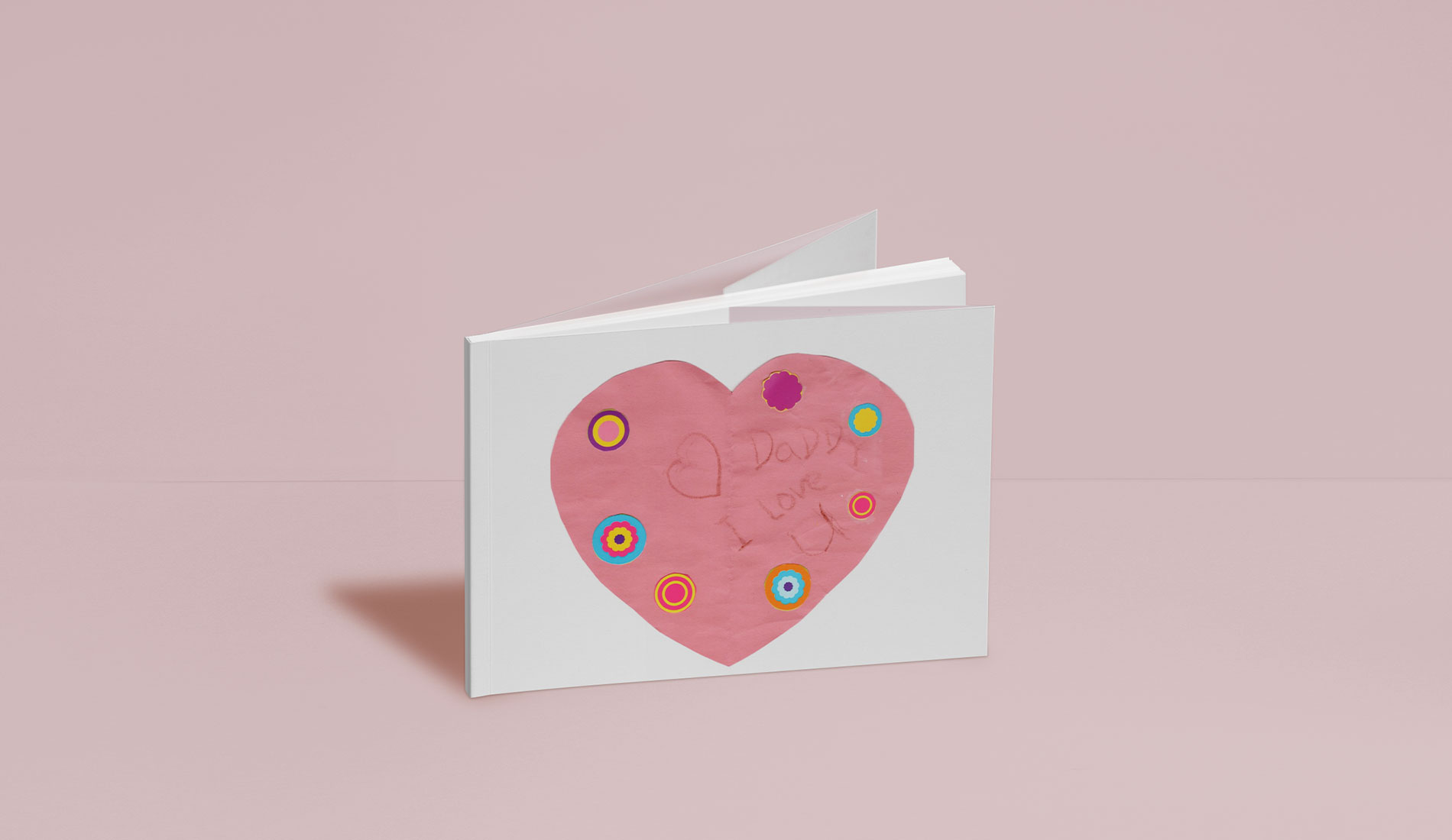 Softcover photo book with child's drawing on cover.
