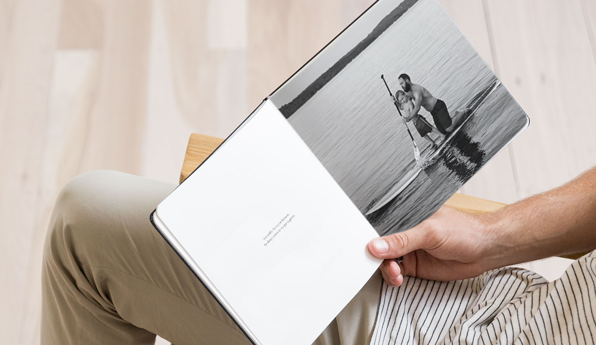 Open photo book with text on one page and a photo of a father and son on a paddle board on the other