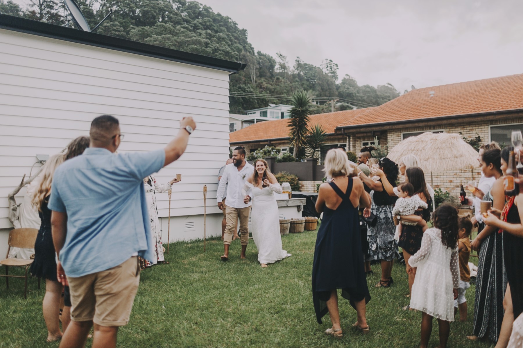 Newlyweds being greeted by friends and family at outdoor reception