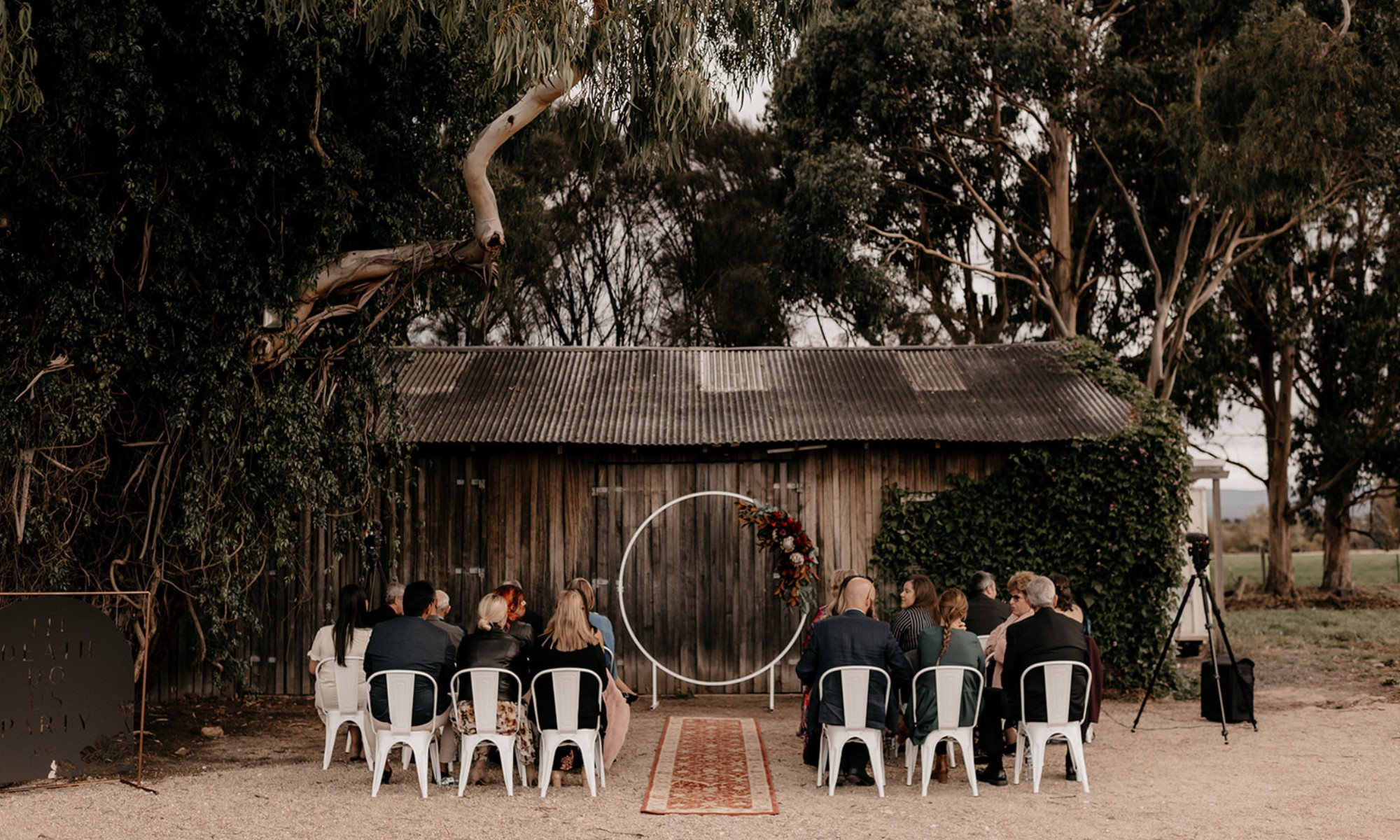 Small group of wedding guests gathered and seated for ceremony