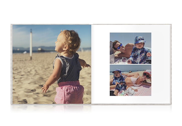 Open photo book with images of young toddler and parents at the beach