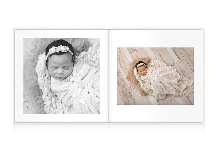 Open photo book with images of a newborn baby