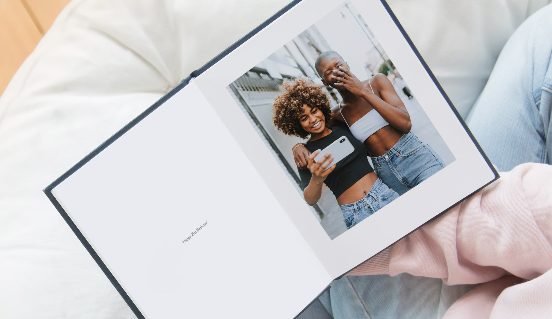 Open portrait photo book with text 'happy 21st Birthday' and image of two women taking a selfie