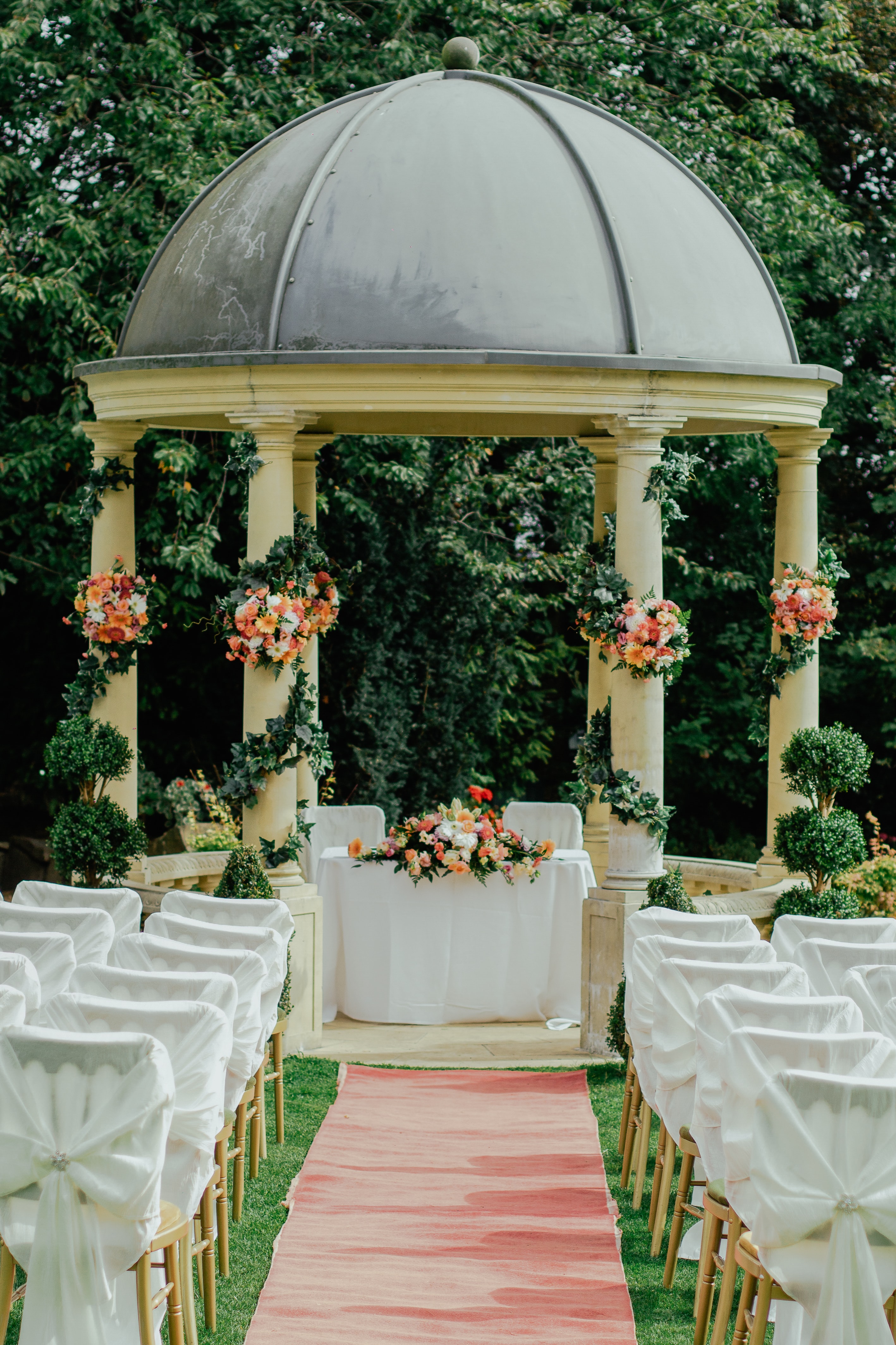 Formation de chaises décorées de manière colorée pour une fête de mariage dans la nature.