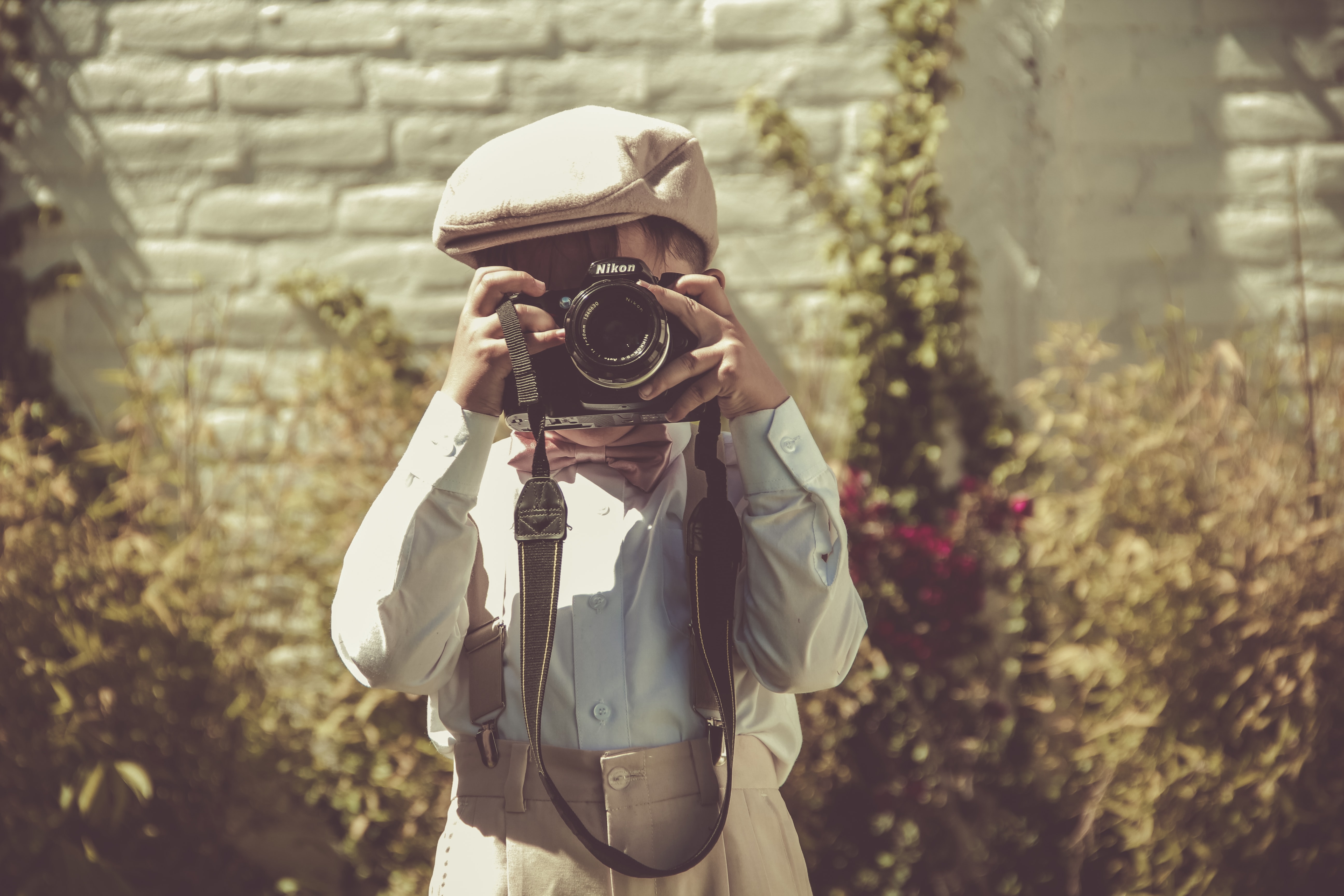 Petit garçon bien habillé regardant dans un appareil photo et prenant une photo.