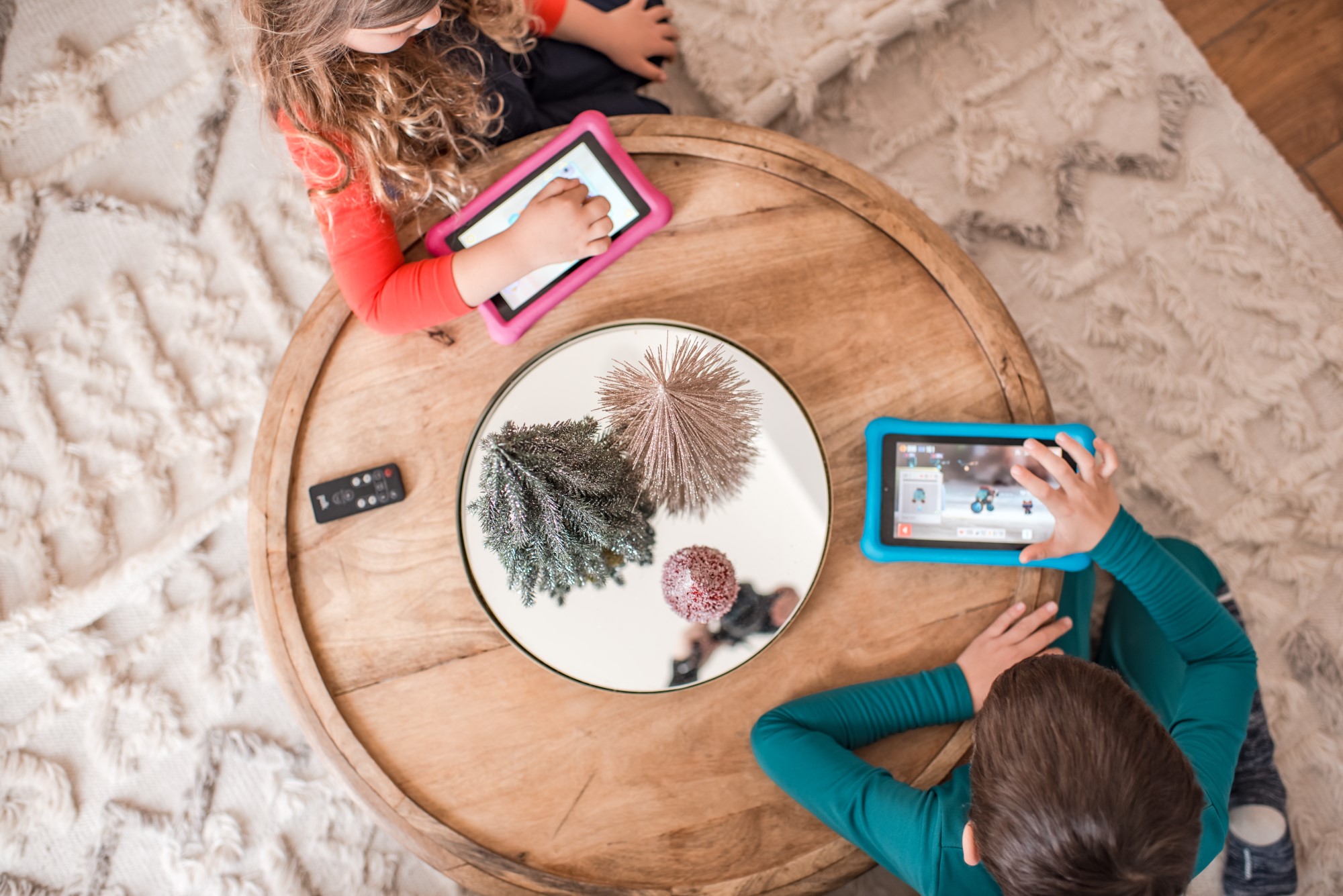 Two kids on screen devices indoors