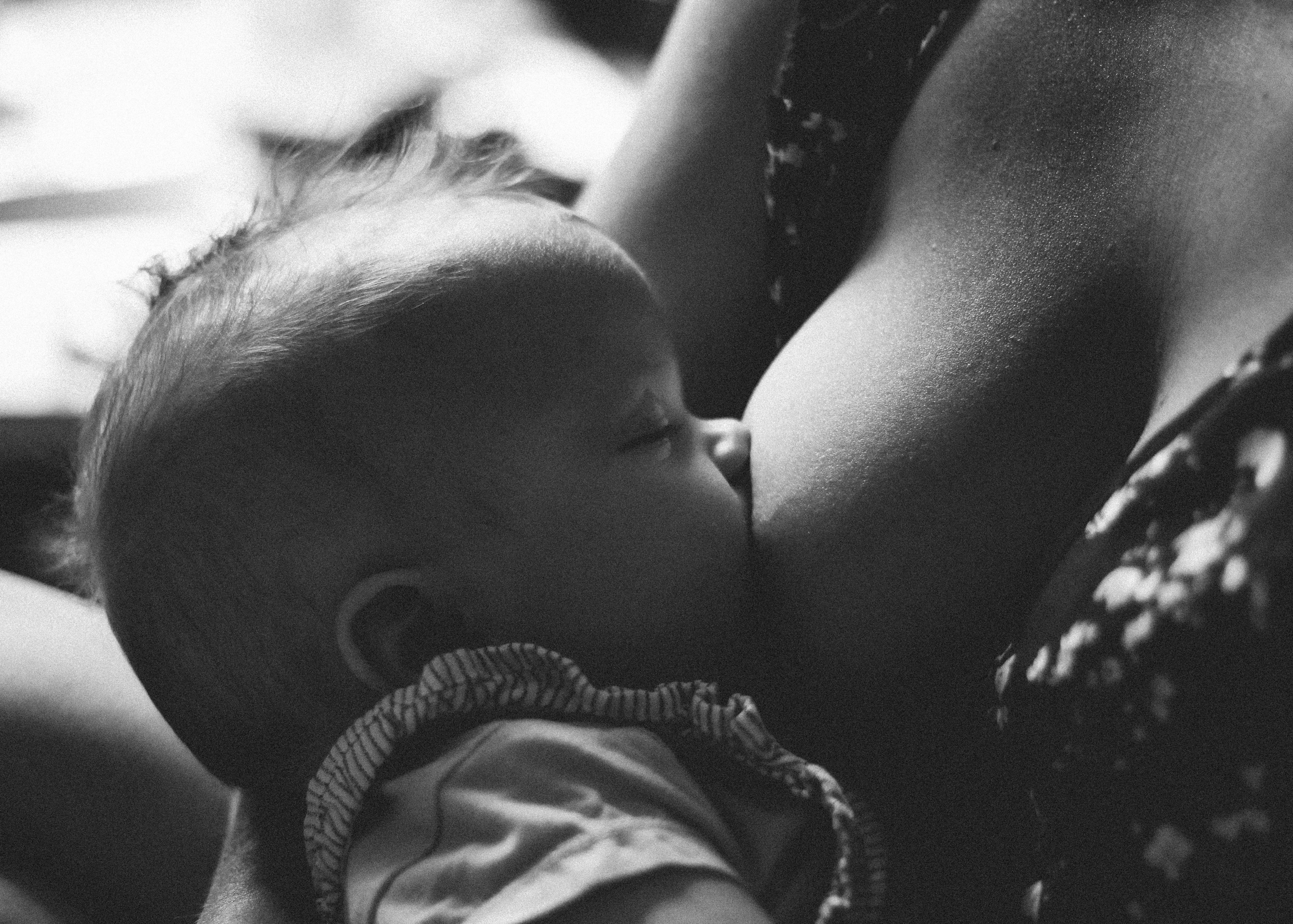 Schwarzweiß-Bild einer Mutter beim Stillen ihres Babys.
