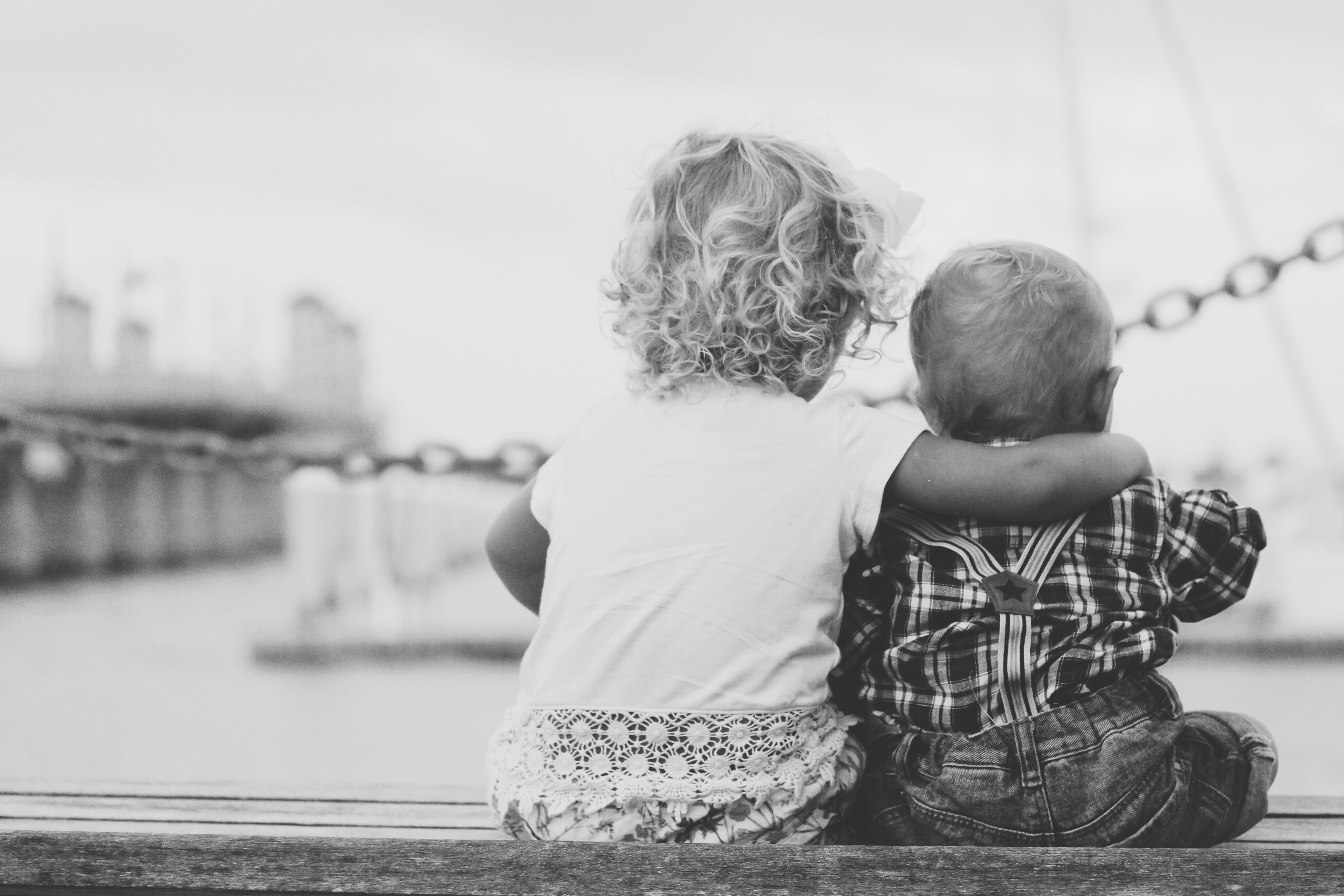 Image en noir et blanc de deux enfants en bas âge se faisant des câlins.