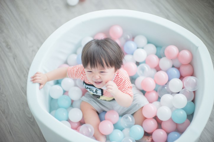 Un petit enfant joue dans une piscine à balles.