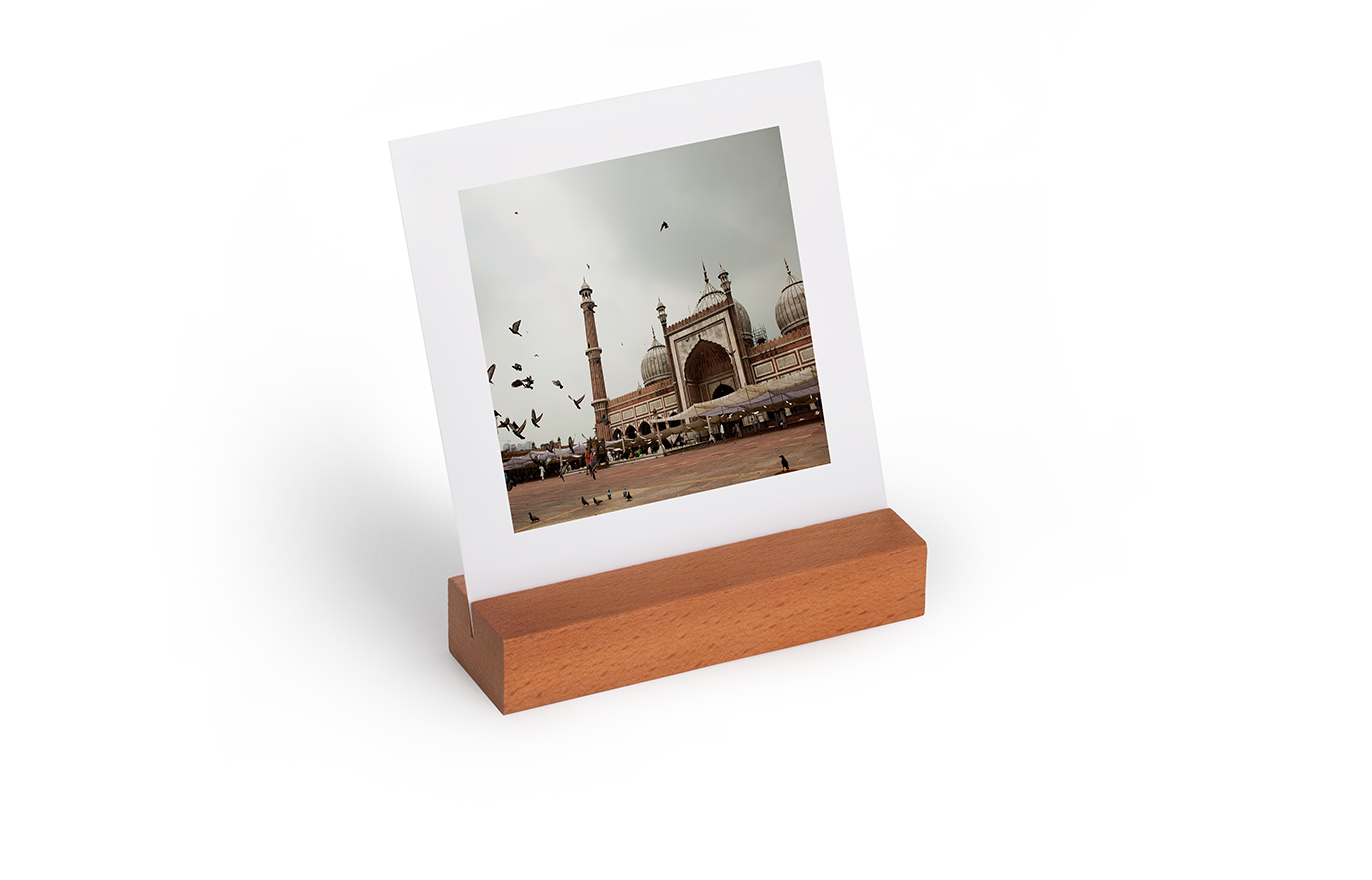 A mini travel art print sitting in its wooden display block.