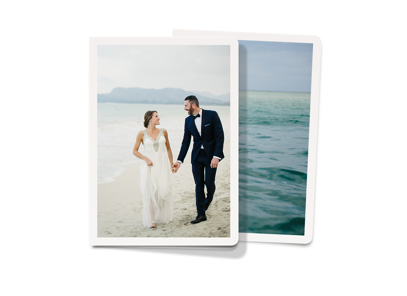 Due biglietti d'auguri con ritratto. Uno con una coppia di sposi sulla spiaggia e uno con una fotografia panoramica dell'oceano.