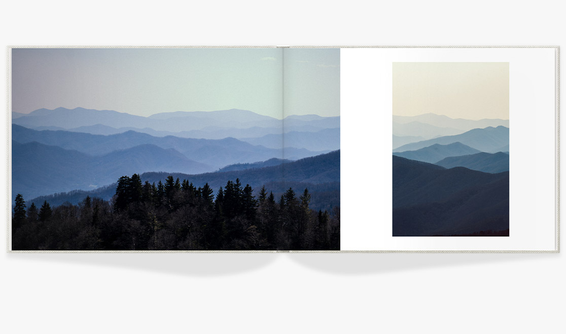 Open photo book showing spread of landscape photos