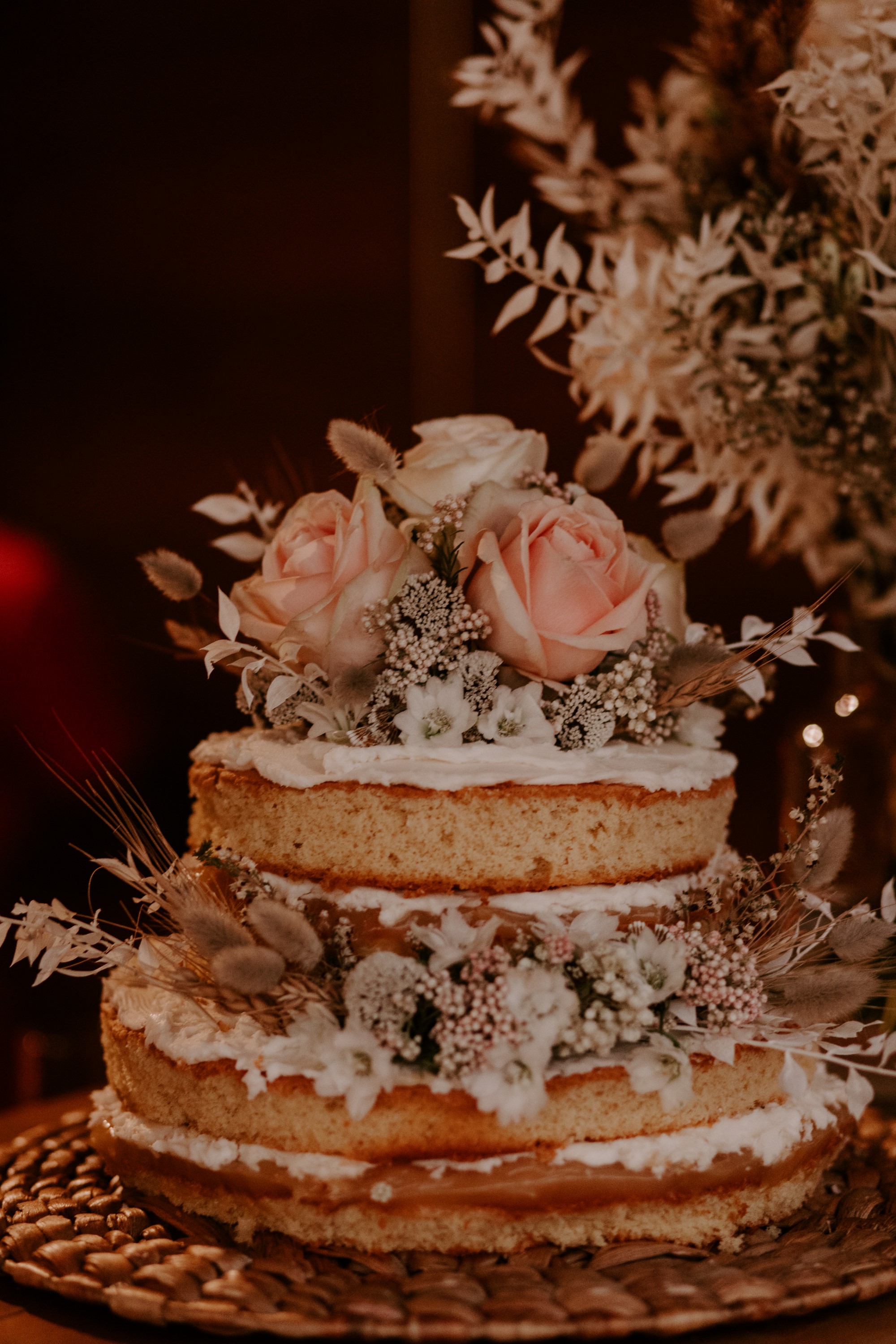 Tarta de boda de dos pisos decorada con flores.