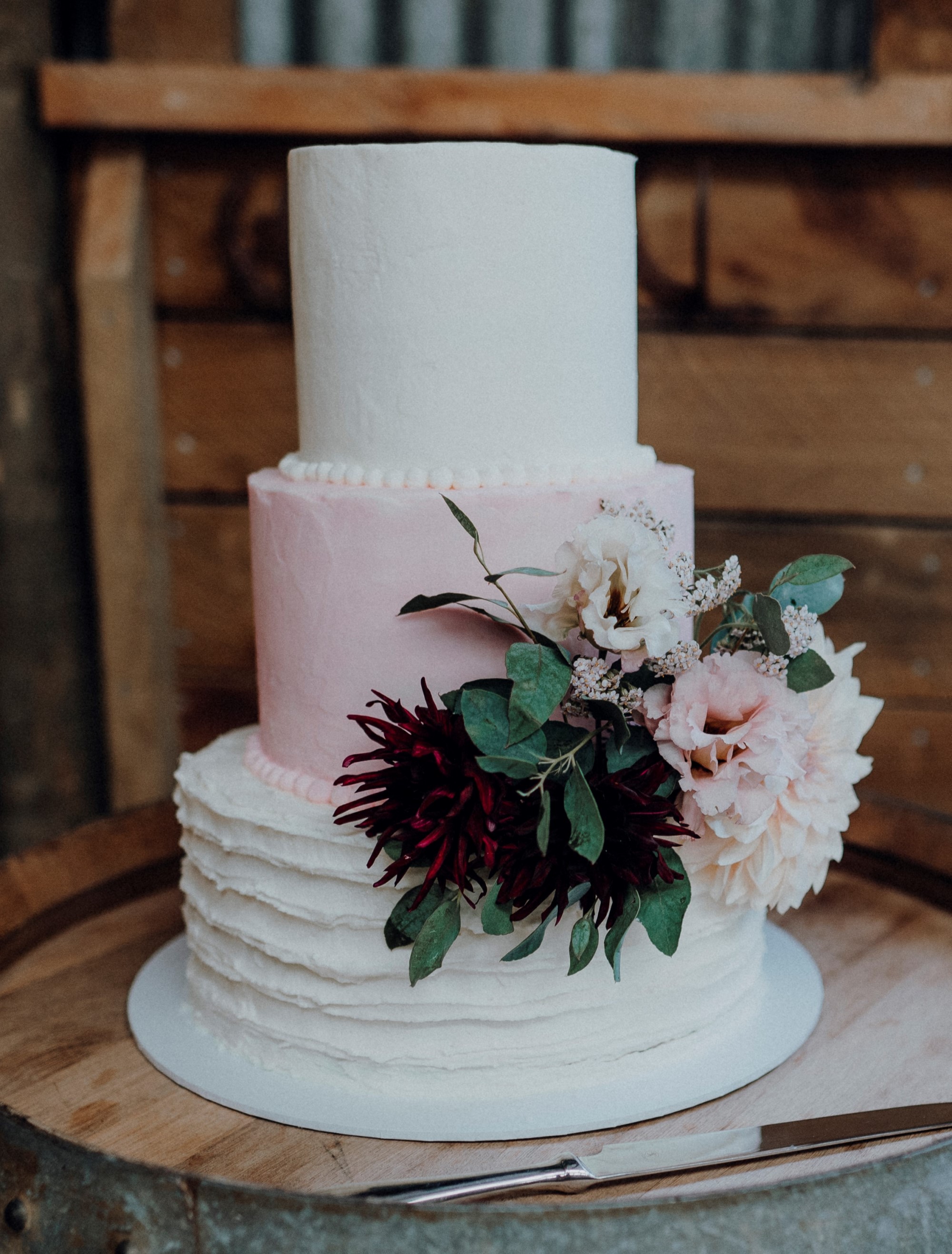 Triple tiered wedding cake with pink middle tier