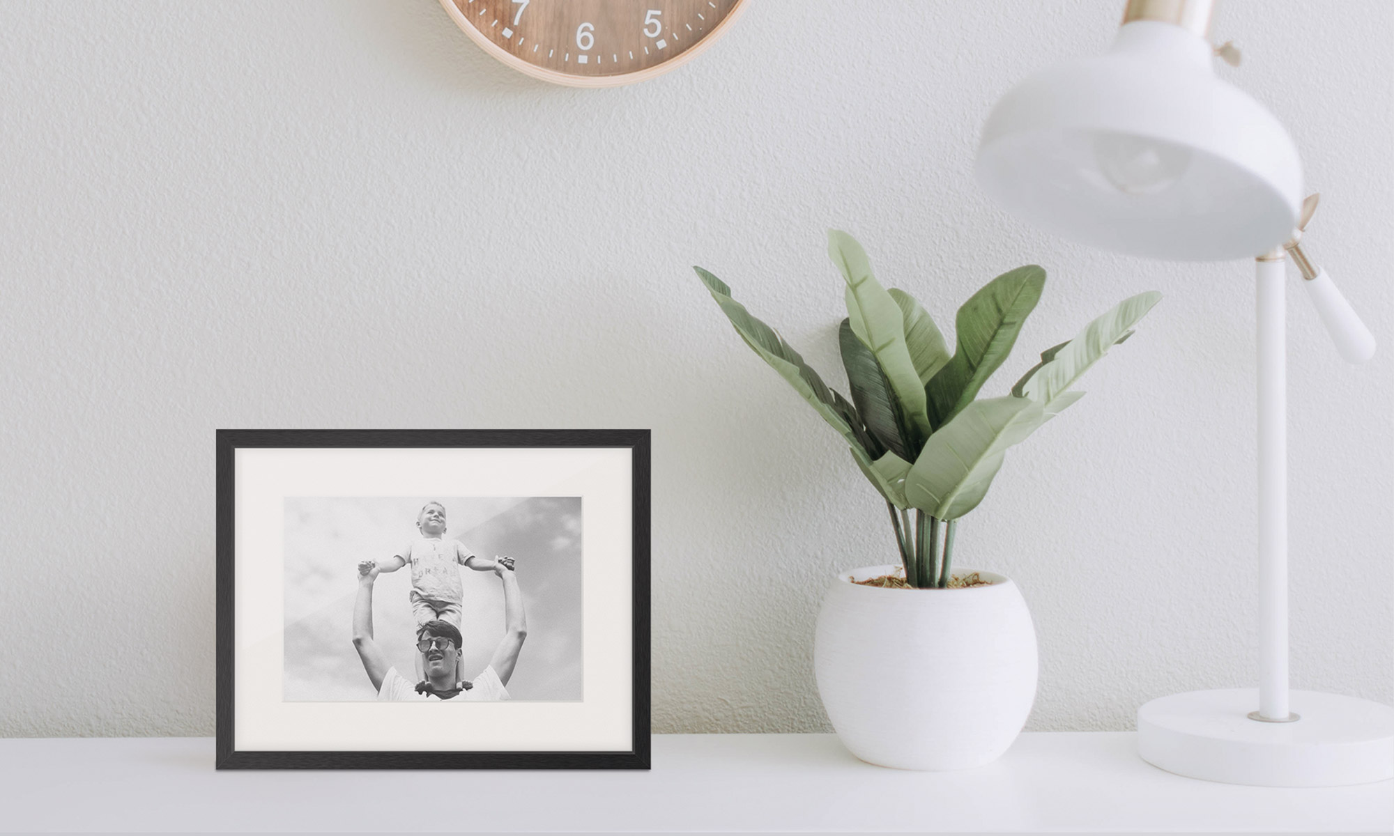 Framed image next to plant and lamp