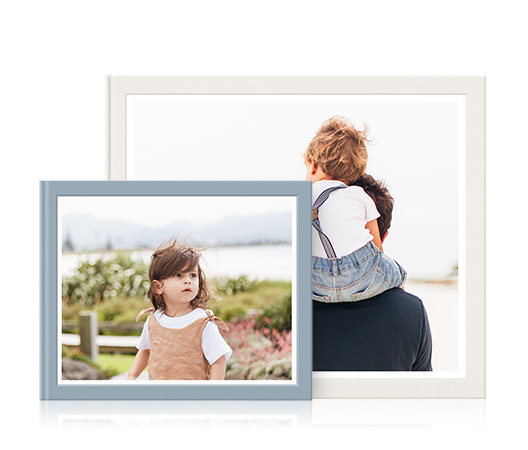 Ein mittelgroßes Fotobuch mit einem Kind auf dem Cover und ein größeres MILK-Fotobuch mit Sohn auf den Schultern des Vaters.