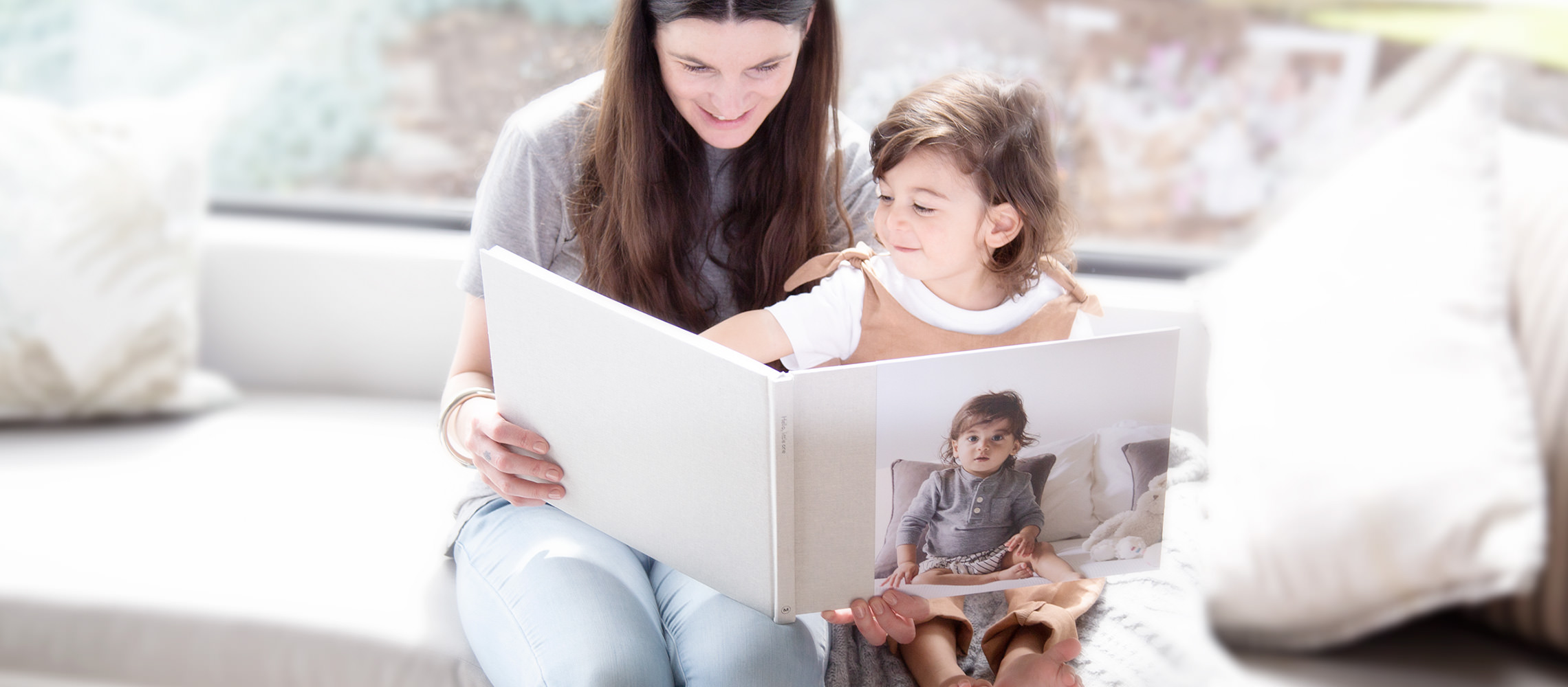 Woman and child looking through her child's baby photo book.