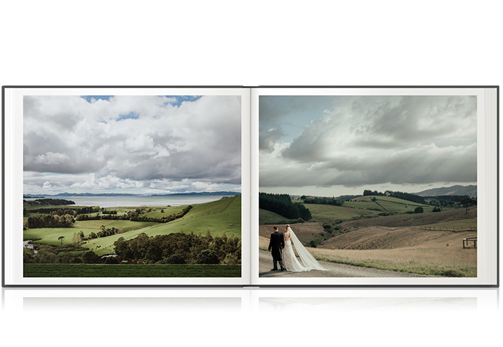 Open photo book showing rolling hills and newlywed couple