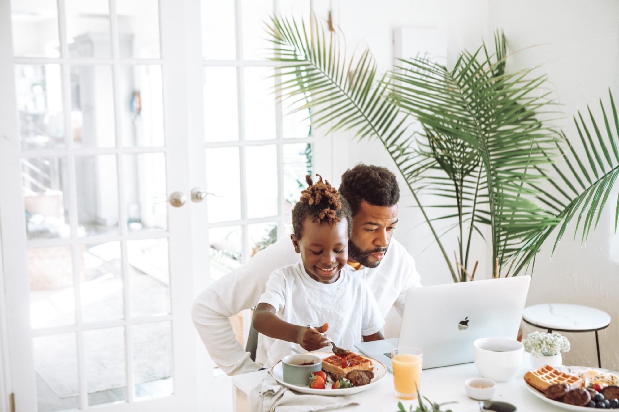 Father and child eat breakfast