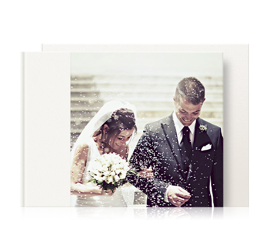 Premium-Hochzeitsfotoalbum im Querformat mit Cover eines frisch verheirateten Paares, das mit Konfetti bedeckt ist.