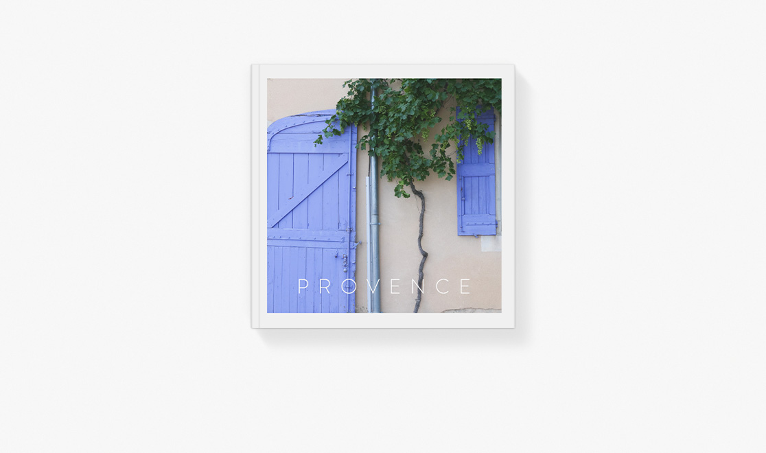 Book on table of blue door and trees in Provence, France