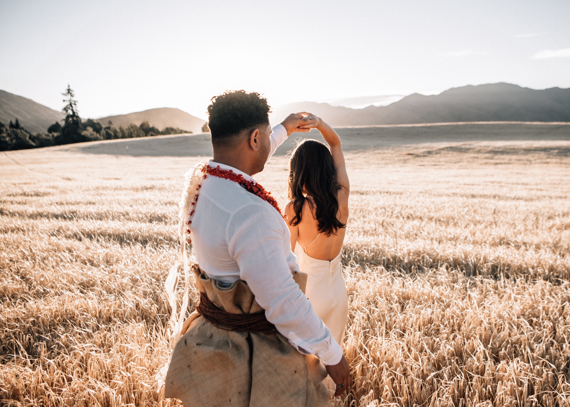 Newlyweds dancing in field