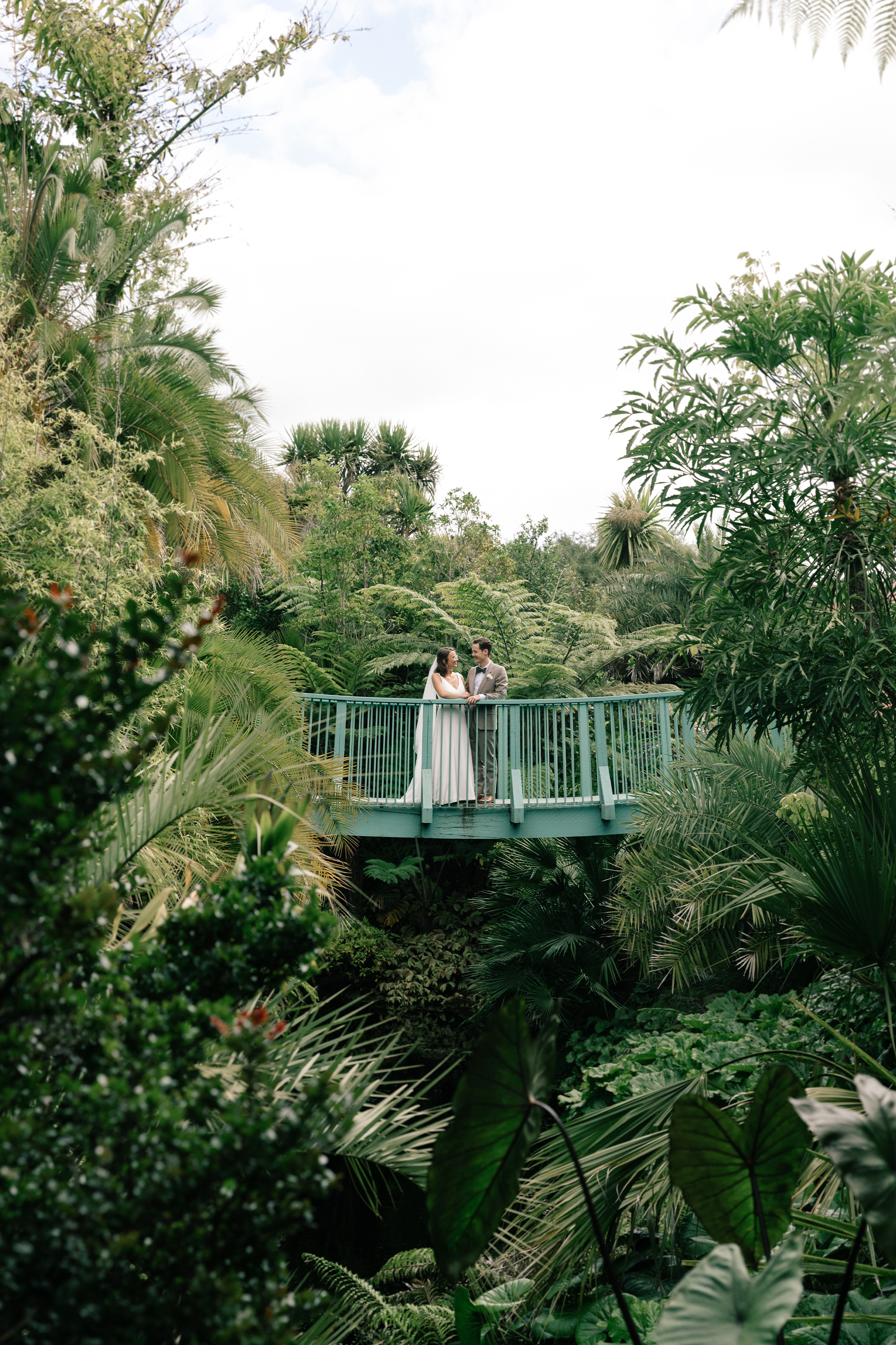 Newlyweds stand on bridge