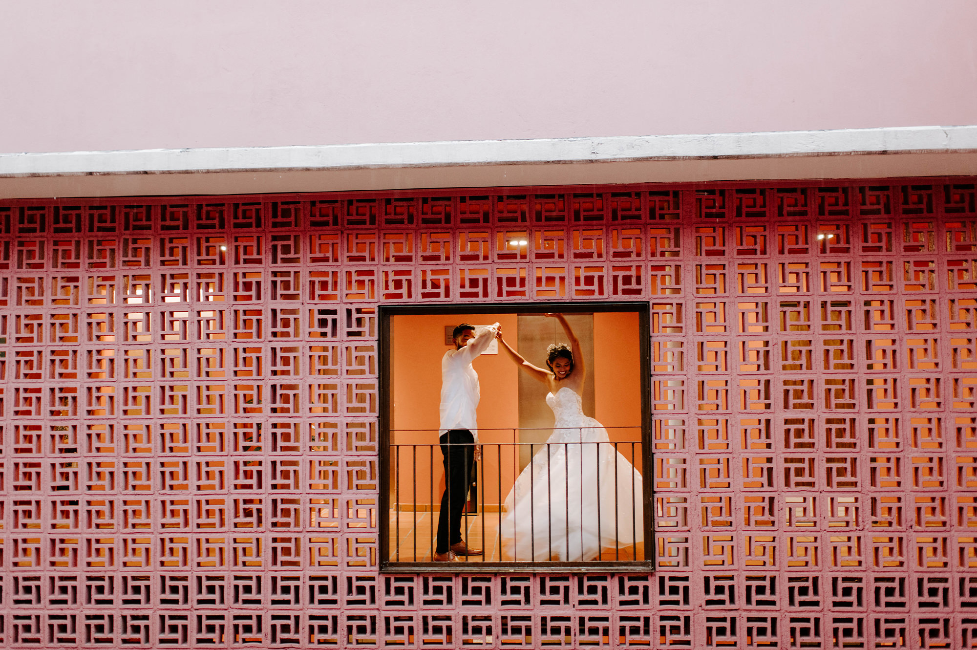 Bride and groom dancing in window