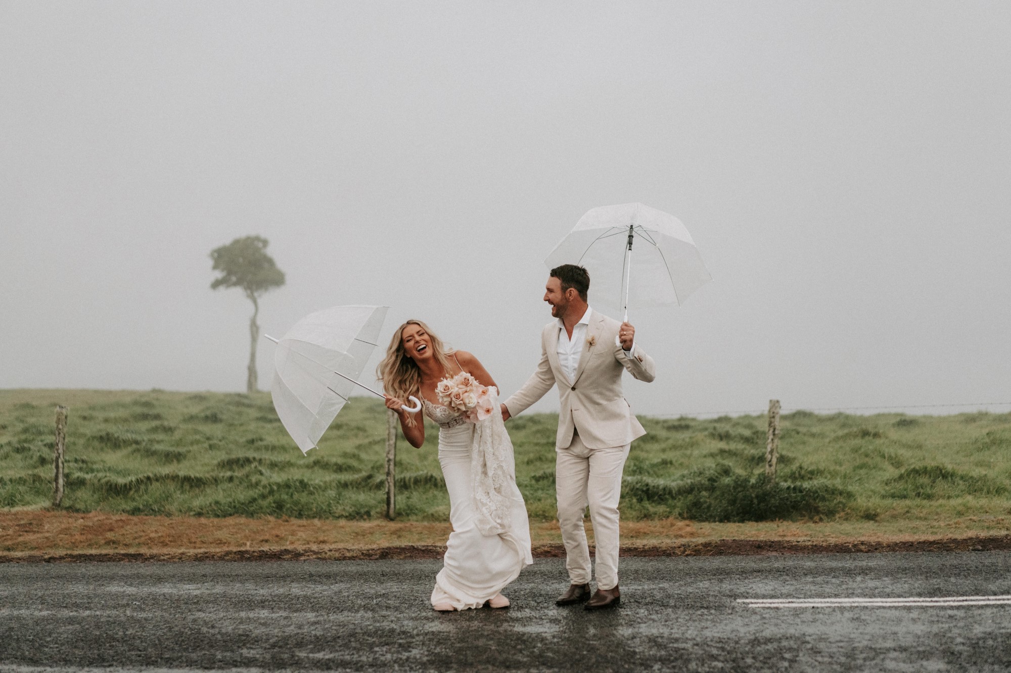 Newlyweds laughing in rain