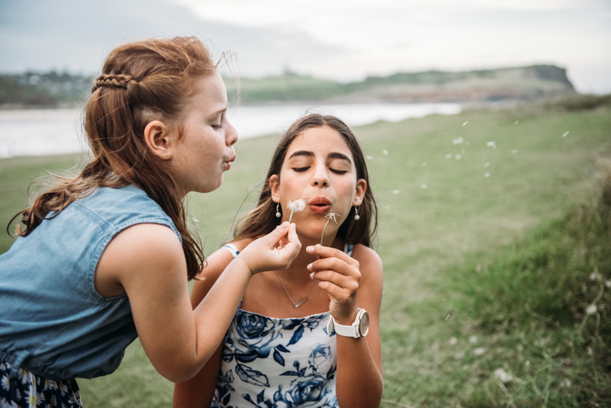 Young girl blowing dandelions