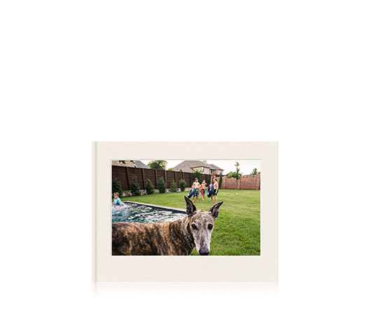 Livro de fotos em formato paisagem com foto de capa de um cachorro.