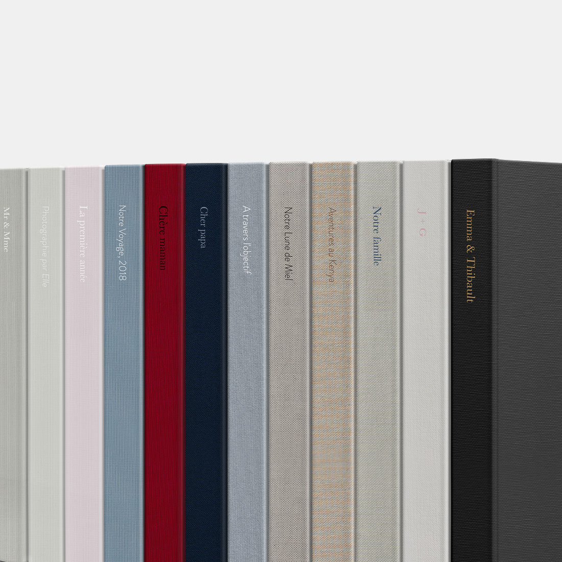 Pile d'albums photo haut de gamme avec différents tissus de couverture.