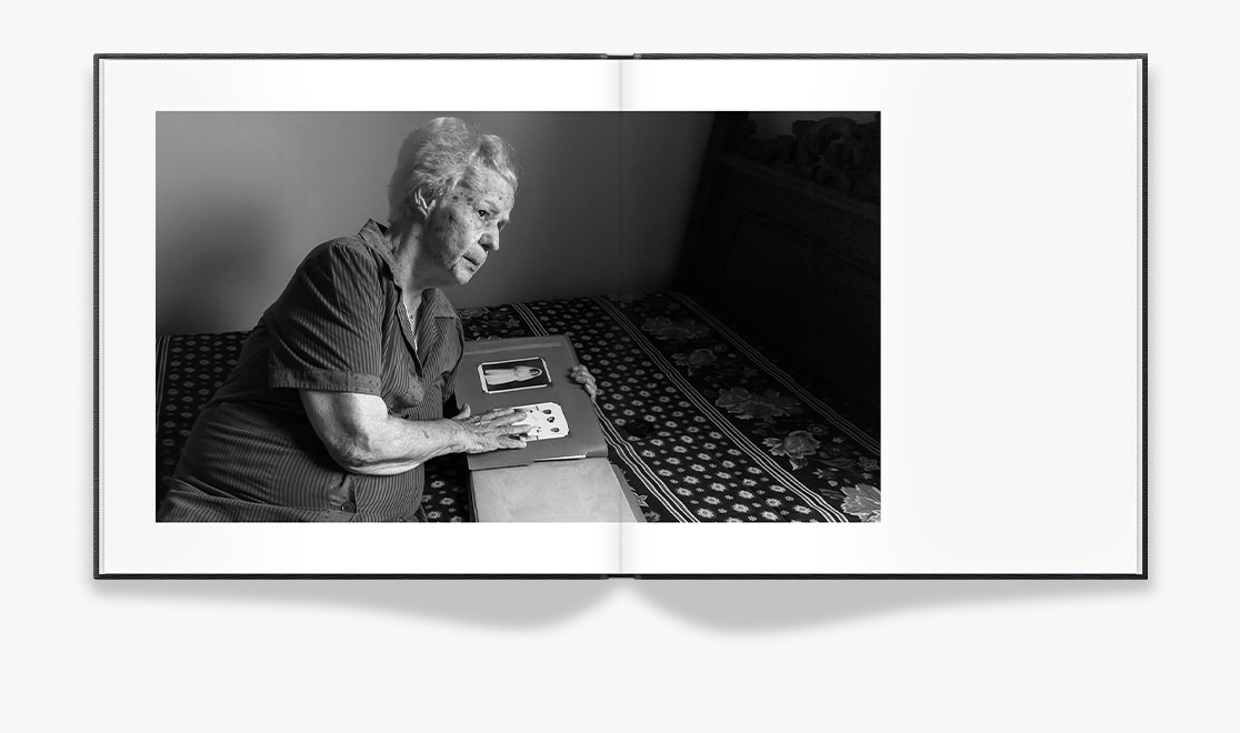 Open book depicting grayscale portrait of old woman.