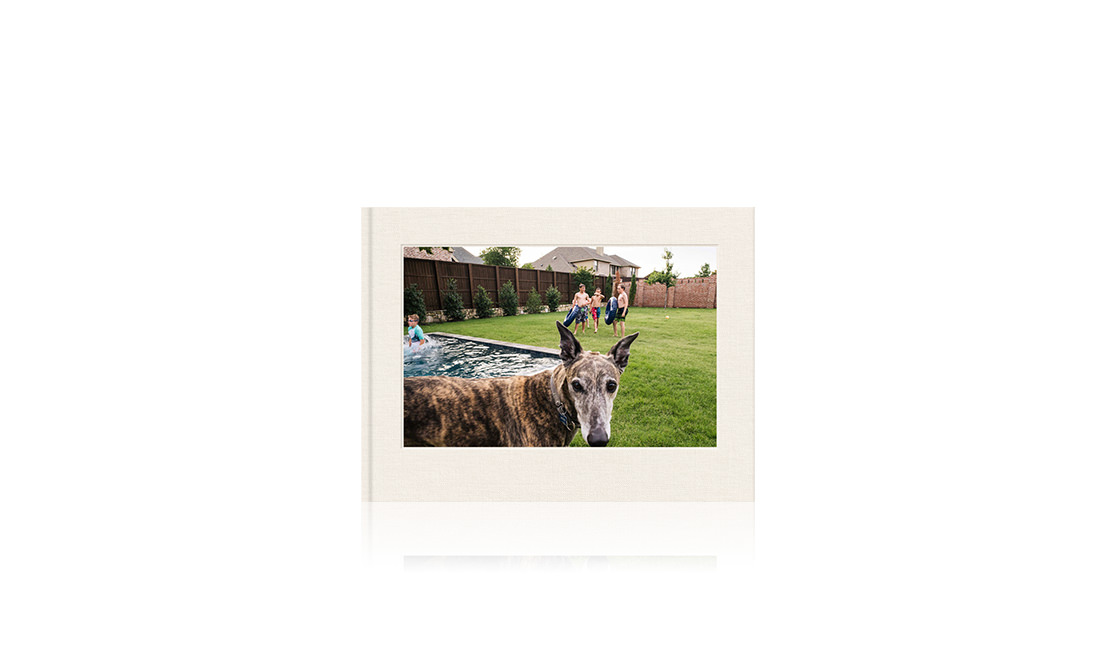 Photo book with cover image of dog and children playing in the garden.