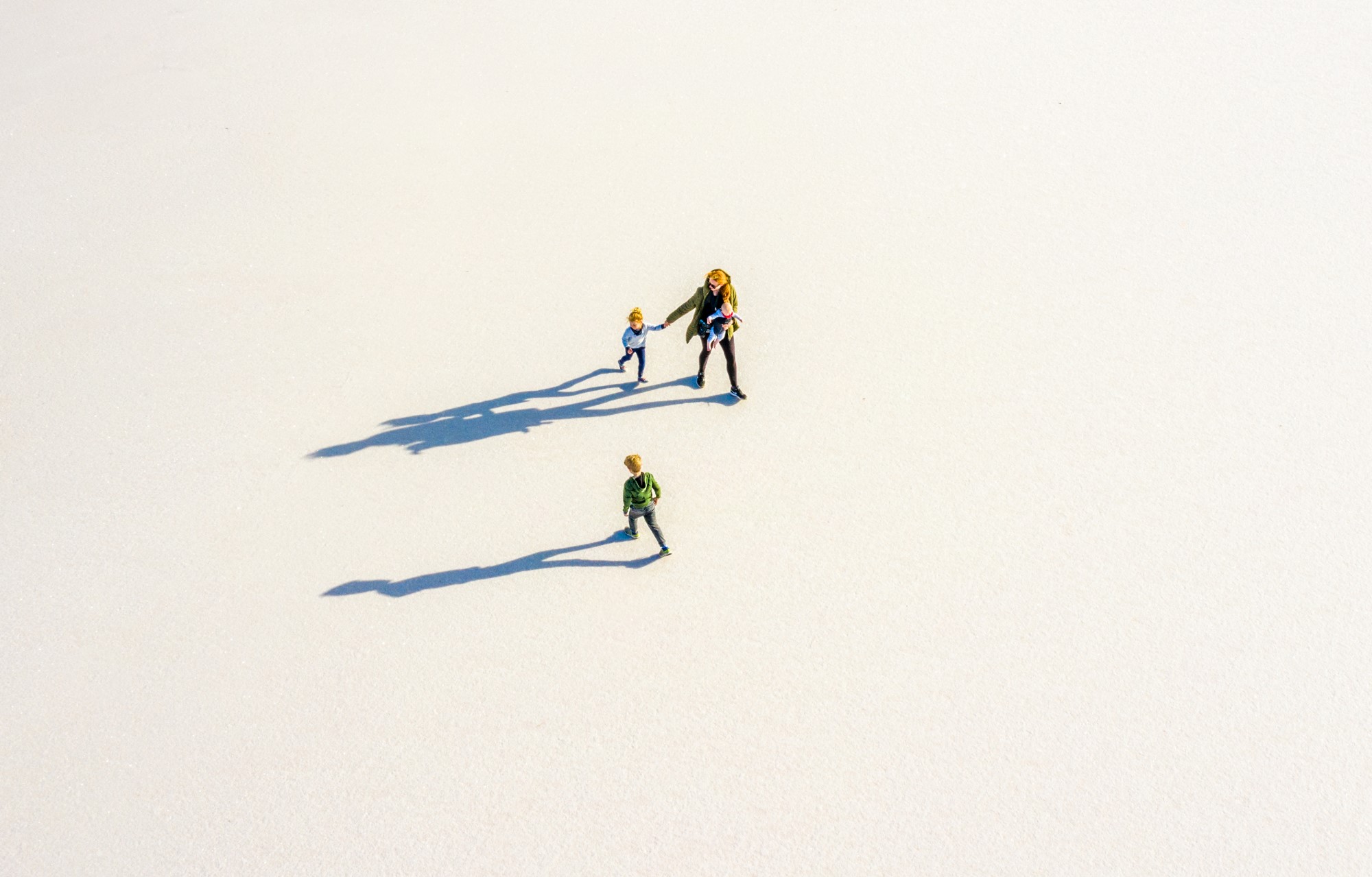 Drone shot of three people walking through plains.