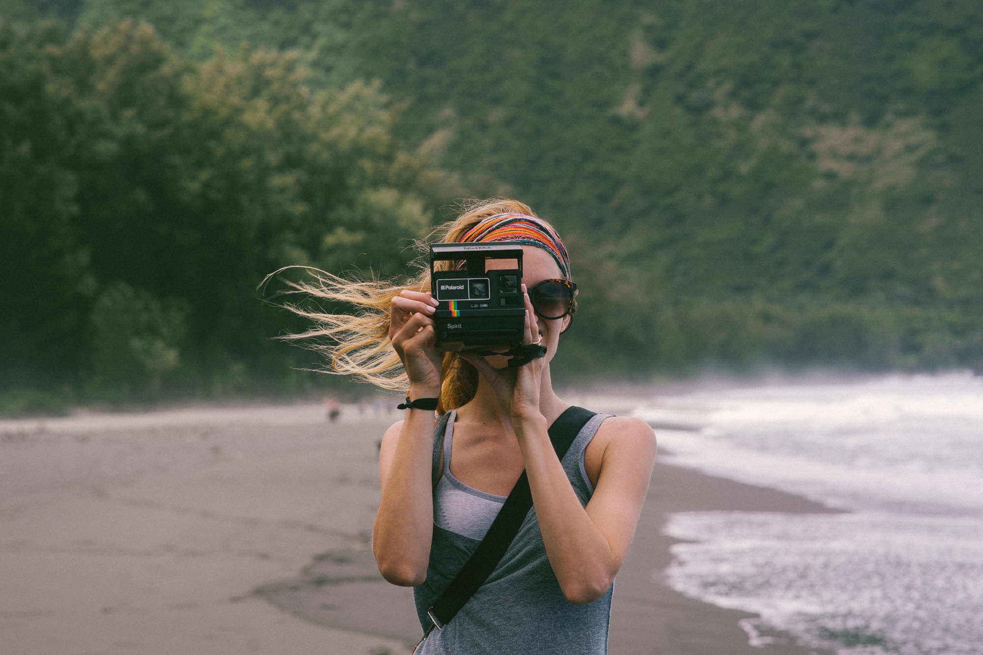 Mujer con una cámara en la playa.