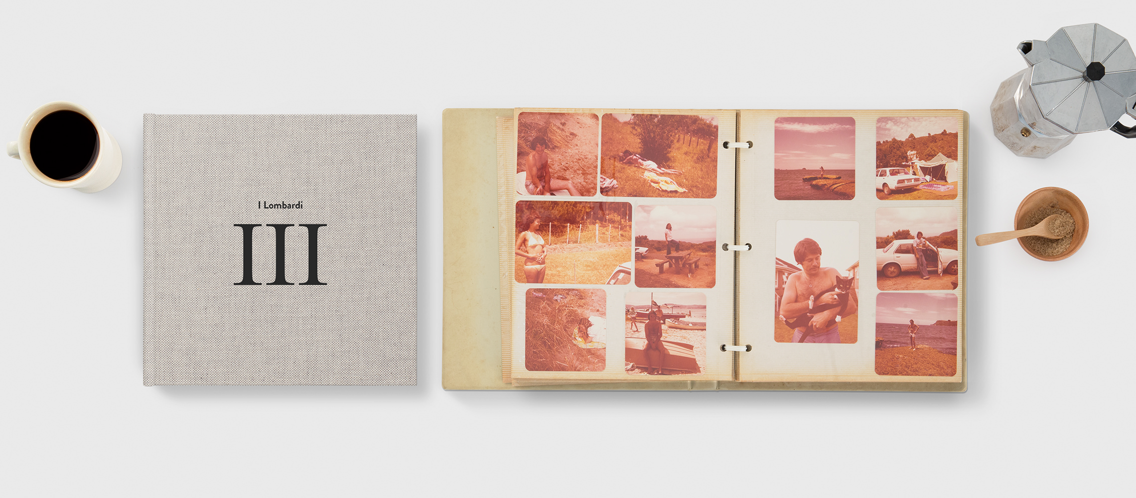 Un fotolibro chiuso e uno aperto con immagini retrò di un viaggio.
