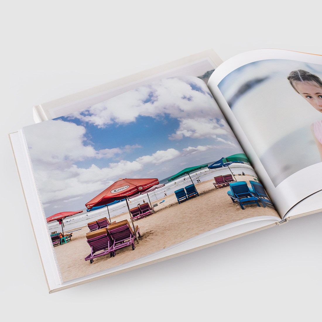 Geöffnetes klassisches Fotobuch mit Strandbild.