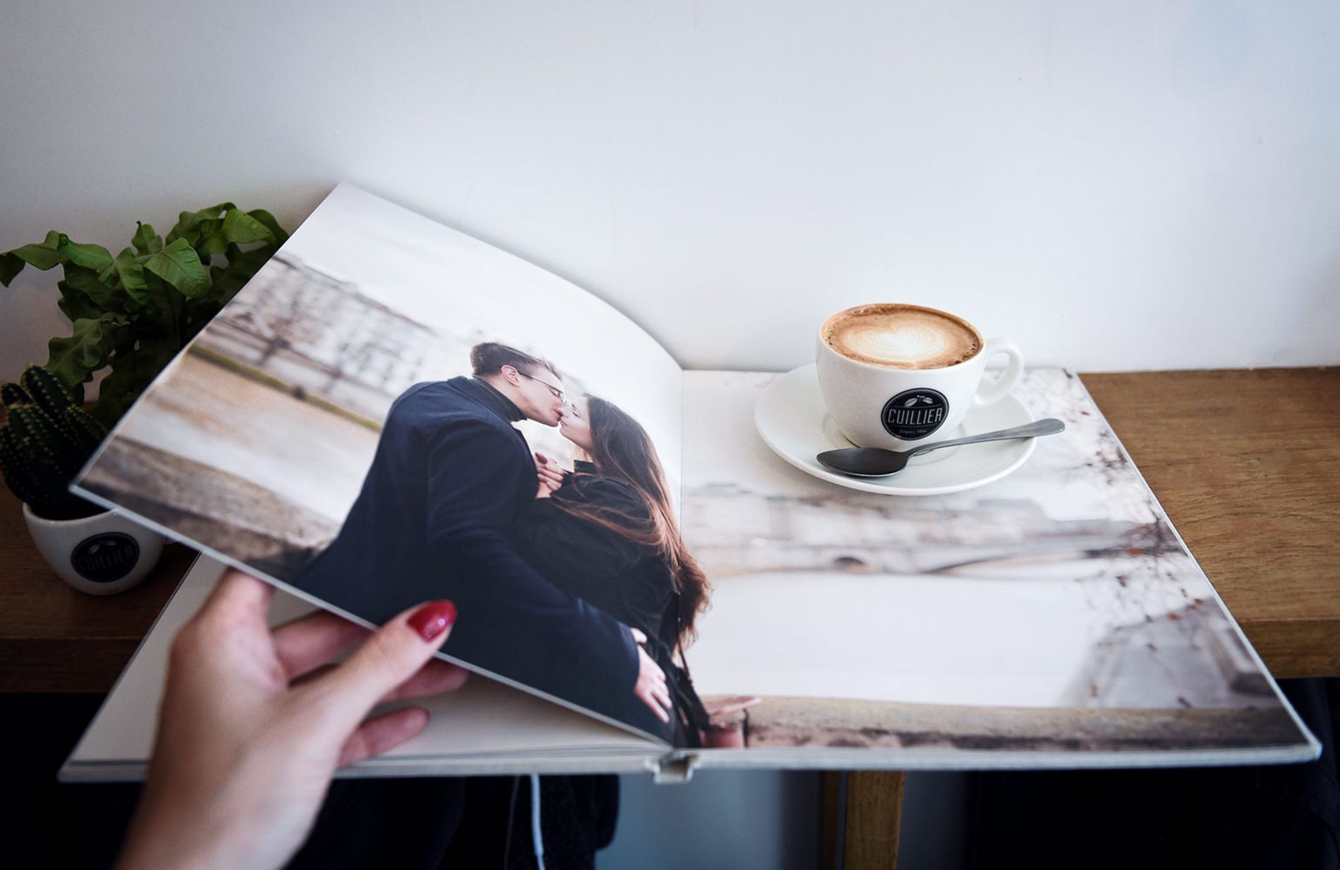Tassee Kaffee ist auf einer Fotobuchseite abgestellt.