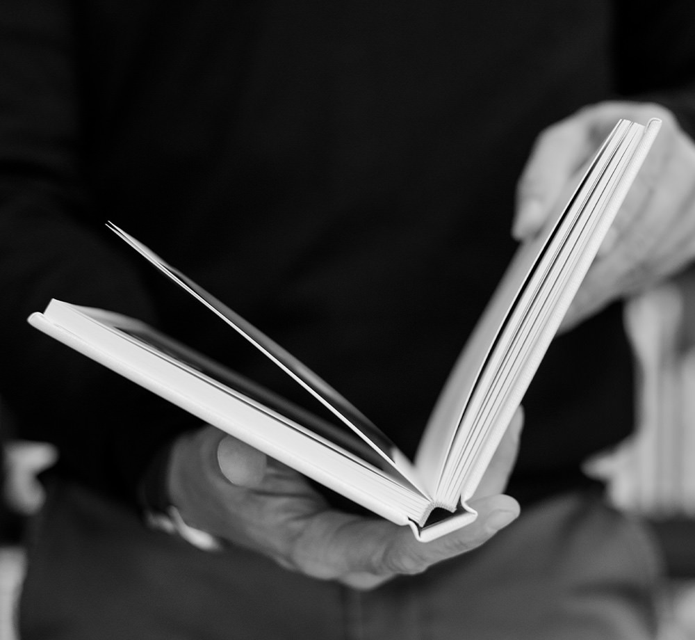 Homme tenant un livre de photos.
