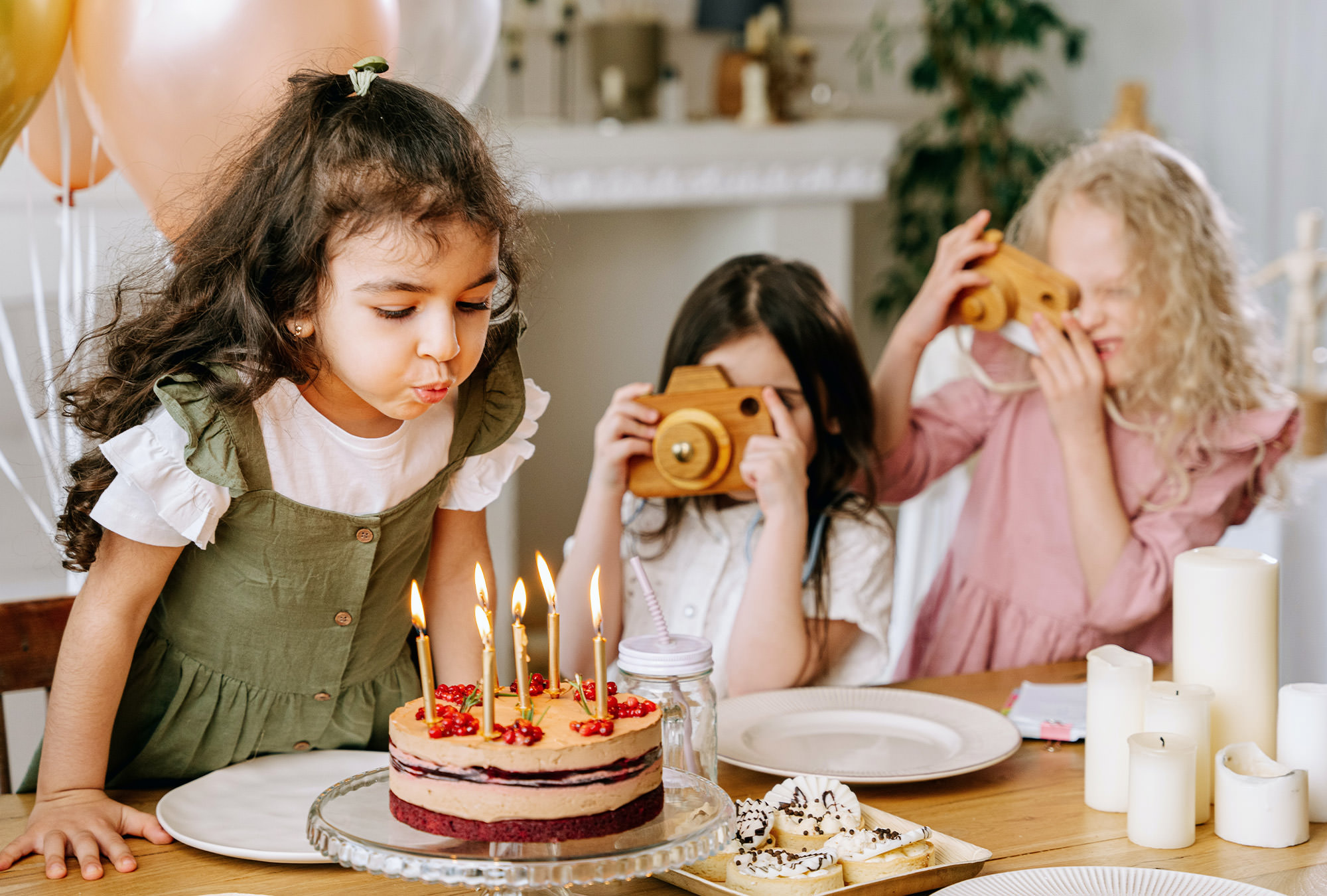 Young girl blowing out candles of birthday cake