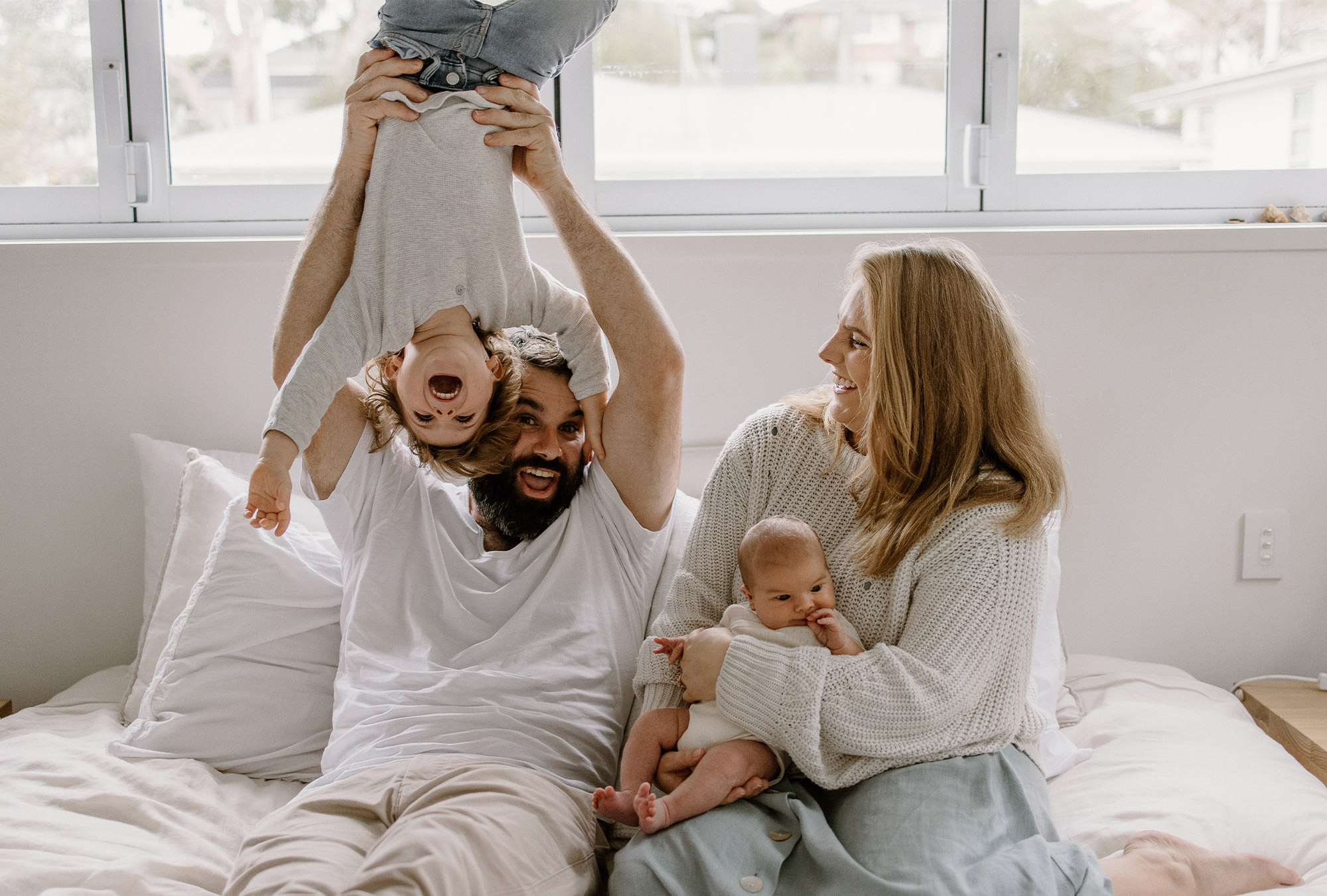 Family of four on bed