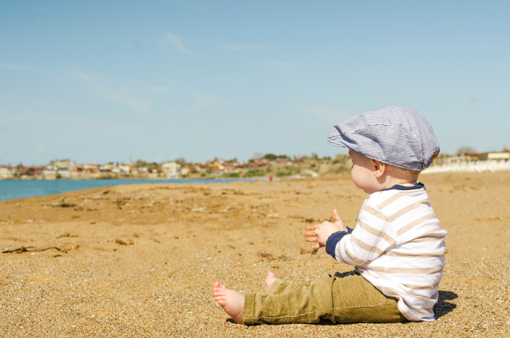 Un petit enfant assis sur la plage.