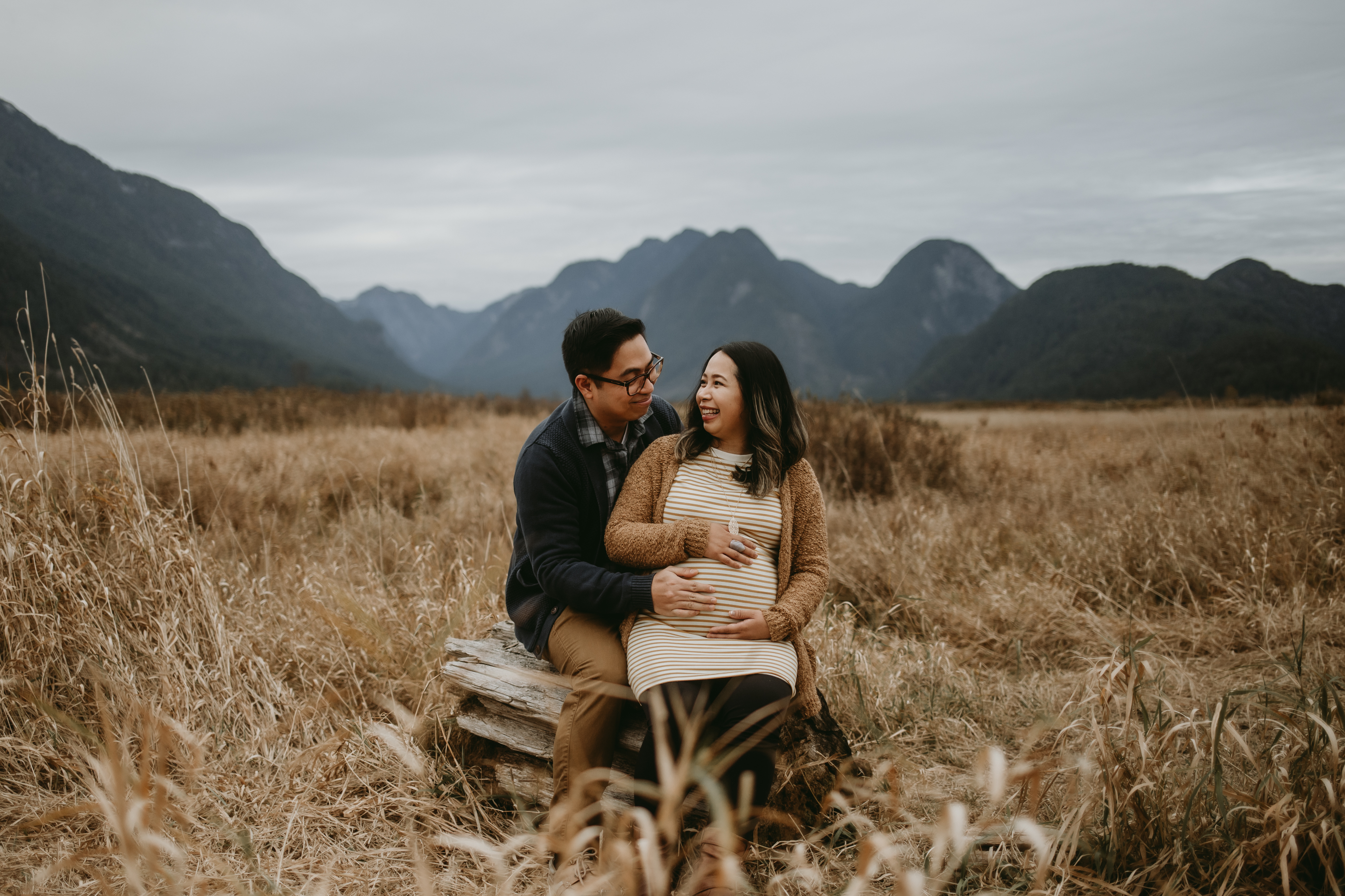 Couple cradling baby bump in maternity photo shoot