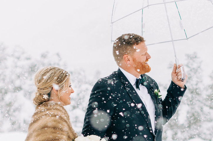 Brautpaar spaziert durch Schnee.